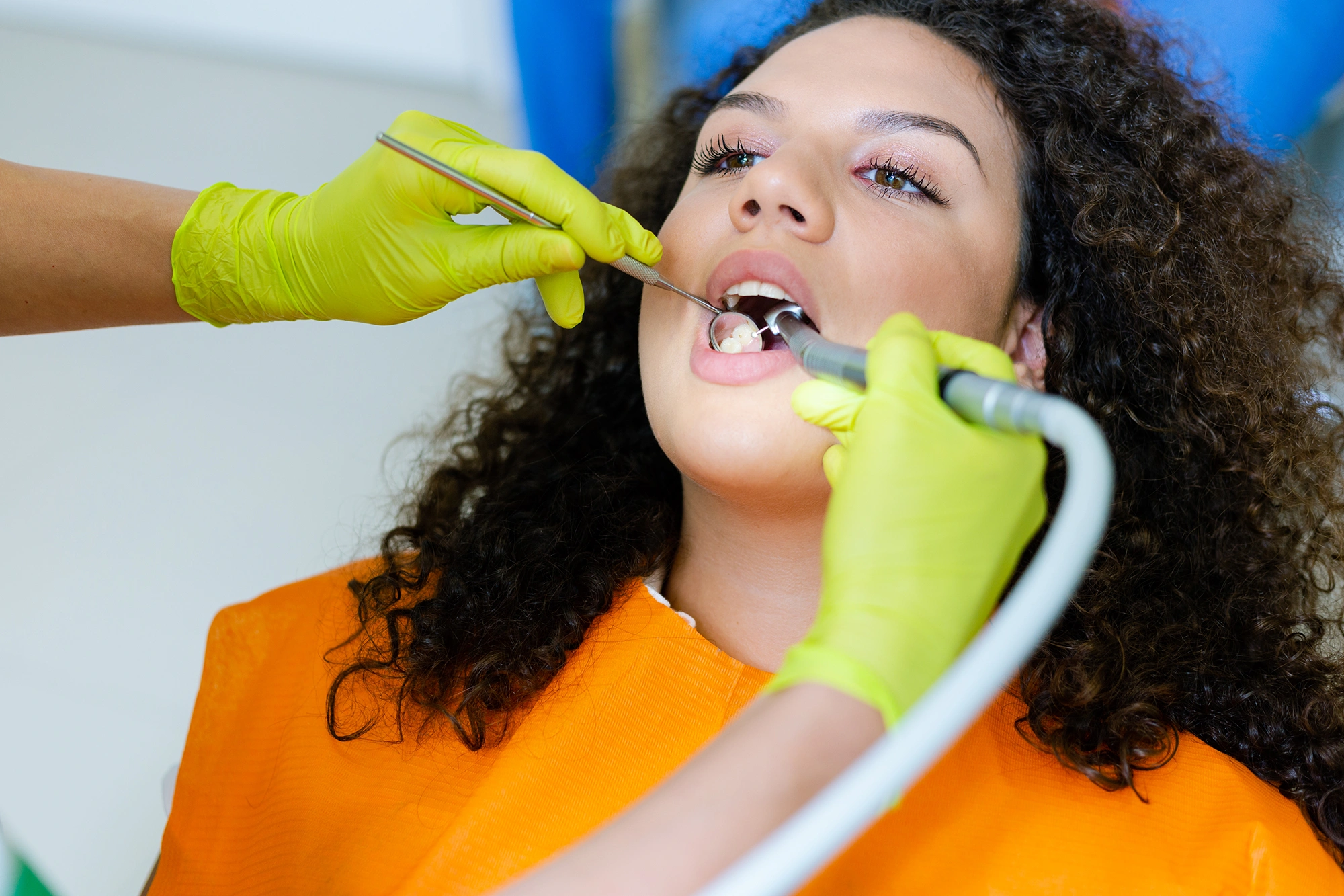 A woman sitting in a dentist's chair while her teeth are examined